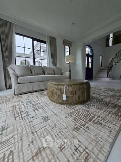 Elegant living room with stylish furniture and large windows in a luxurious home.