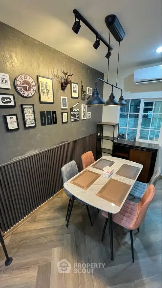 Stylish dining area with modern decor and wall art, featuring a sleek table and colorful chairs.