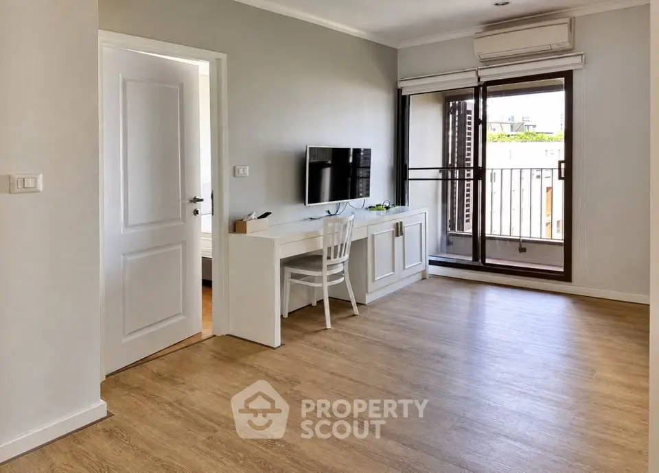 Spacious living room with wooden flooring and balcony access in modern apartment