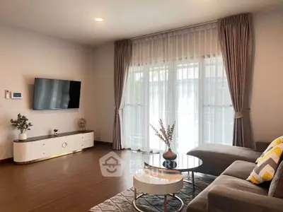 Modern living room with elegant decor and large window curtains