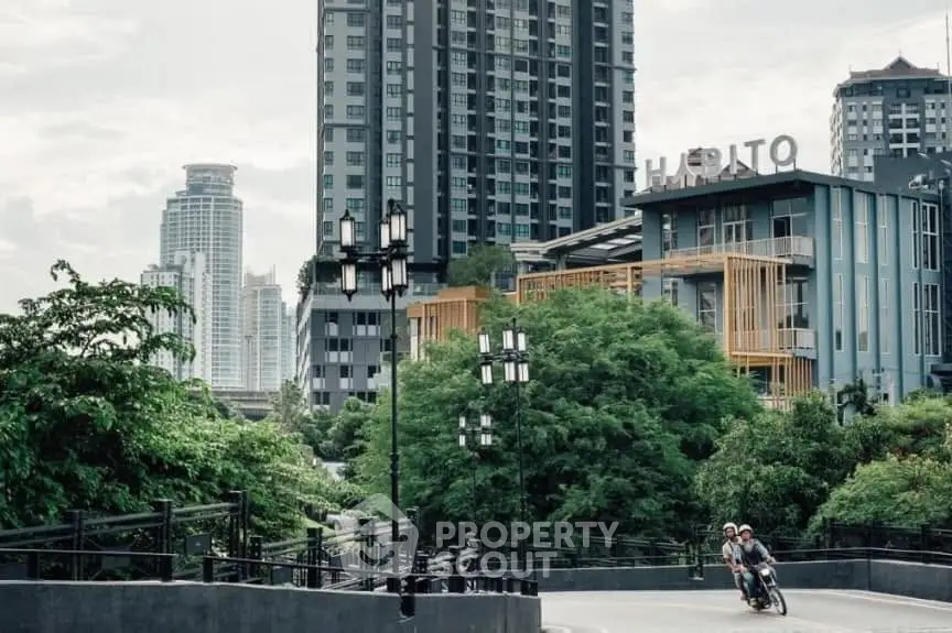 Modern urban apartment buildings with lush greenery and city skyline view.