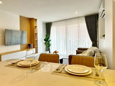 Modern living room with elegant decor and large windows offering natural light.