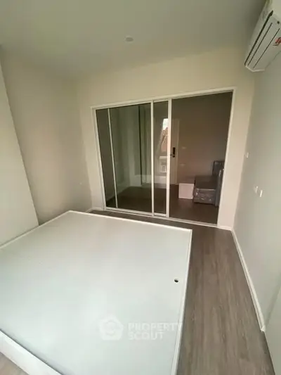Modern bedroom with mirrored closet and air conditioning in a stylish apartment.