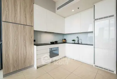 Modern kitchen with sleek white cabinets and built-in appliances in a contemporary apartment.