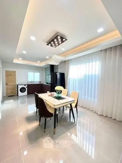 Modern dining area with elegant lighting and open kitchen layout