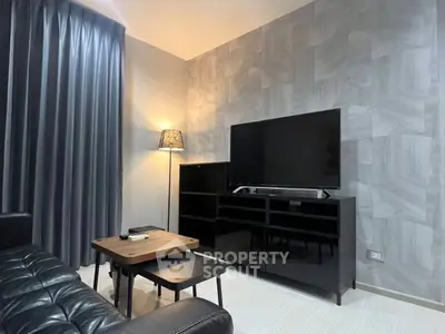 Modern living room with stylish decor, featuring a sleek black TV stand and cozy seating area.