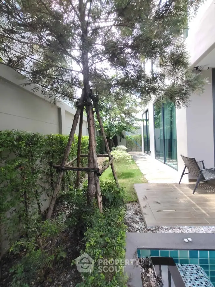 Luxurious garden view with modern architecture and poolside tranquility.