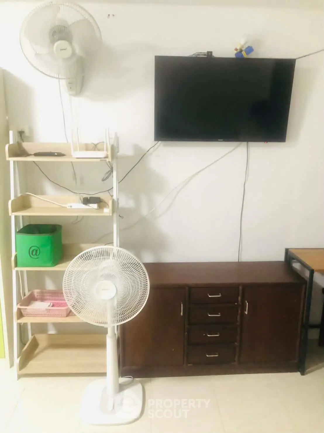 Cozy living room with modern TV setup and ample storage space.