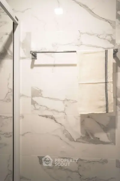 Elegant bathroom with marble tiles and towel rack