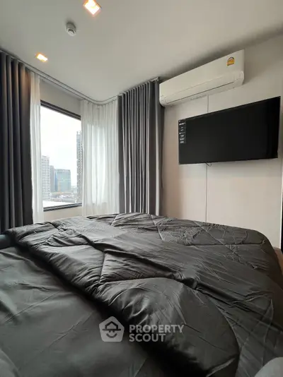 Modern bedroom with city view, featuring sleek design and wall-mounted TV.