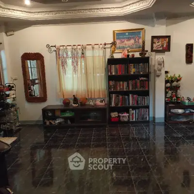 Charming living room with elegant decor, bookshelves, and intricate ceiling design, perfect for cozy gatherings.
