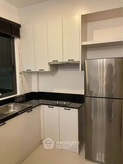 Modern kitchen with sleek cabinets and stainless steel fridge