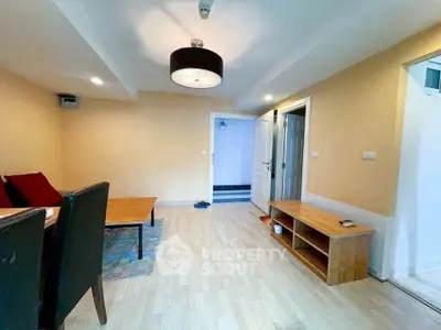 Spacious living room with modern furniture and wooden flooring in a cozy apartment.