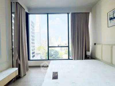 Bright bedroom with large windows offering stunning city views in modern apartment.