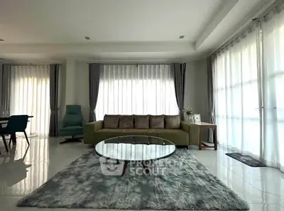 Spacious modern living room with elegant decor and large windows for natural light.