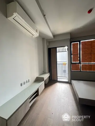 Modern minimalist bedroom with air conditioning and balcony access