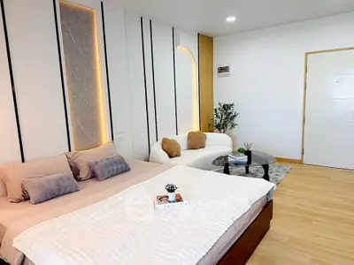 Modern bedroom with stylish decor and cozy seating area, perfect for relaxation and comfort.