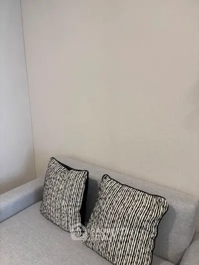 Modern living room with stylish sofa and decorative cushions in a cozy setting.