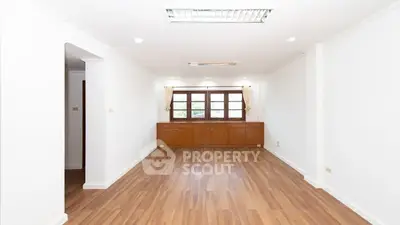 Spacious empty living room with wooden flooring and large window