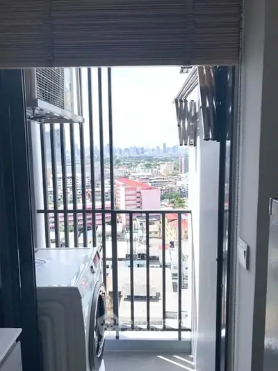 Compact balcony with city view and washing machine, perfect for urban living.