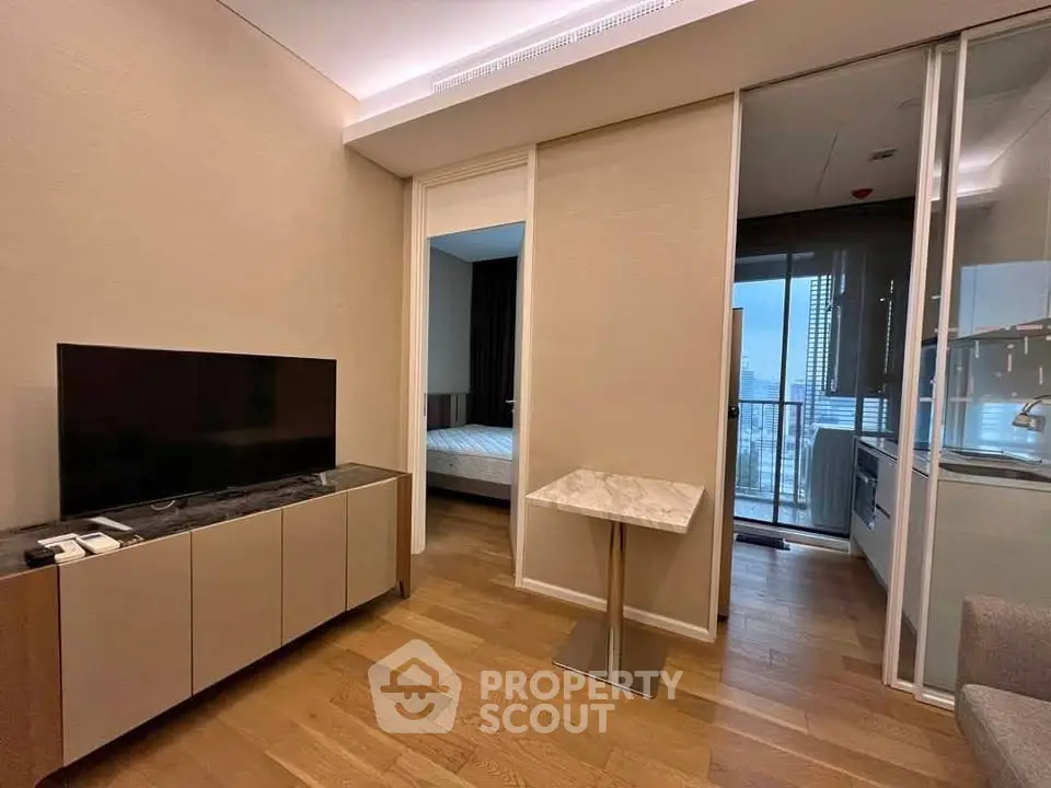 Modern apartment interior with sleek design, featuring a cozy living area and a glimpse of the bedroom.