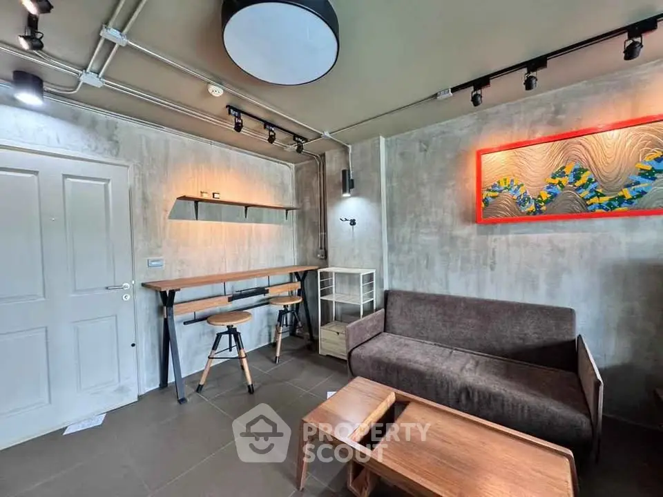Modern industrial-style living room with sleek furniture and artistic wall decor.