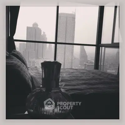 Luxurious bedroom with stunning city skyline view from floor-to-ceiling windows.