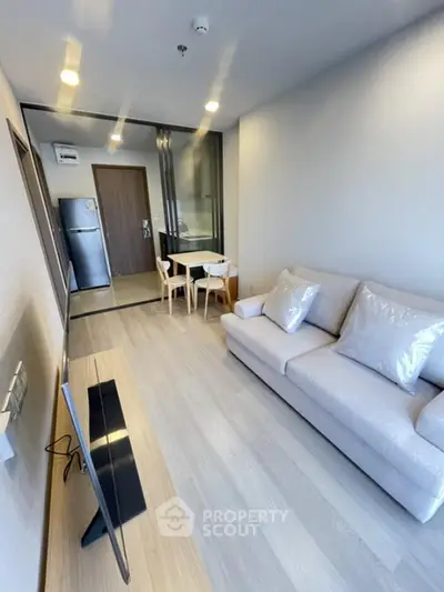 Modern living room with sleek design and open layout, featuring cozy sofa and dining area.