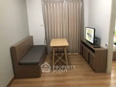 Cozy living room with wooden furniture and TV, perfect for relaxation.