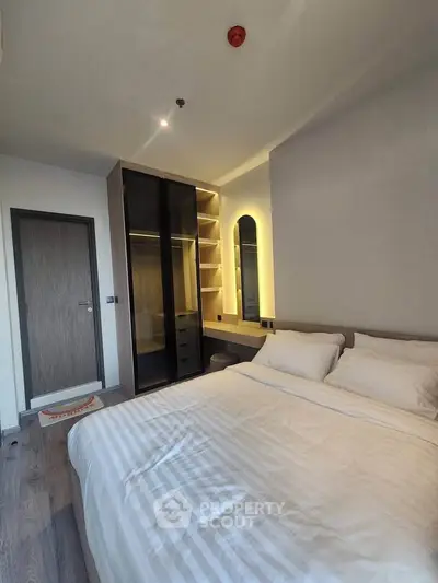 Modern bedroom with stylish lighting and spacious wardrobe in a contemporary apartment.