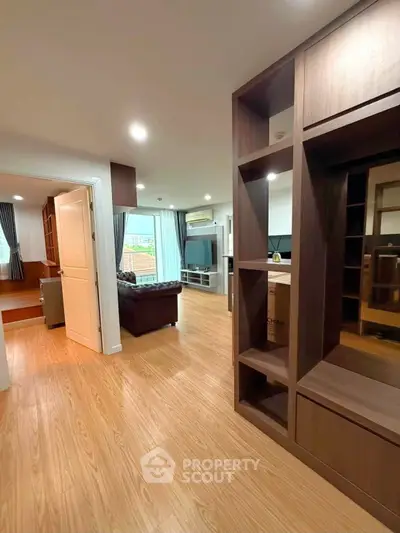 Spacious modern living room with wooden flooring and stylish shelving unit