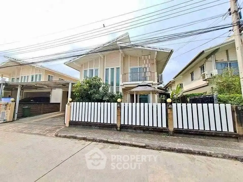 Charming two-story house with modern design and fenced yard in a serene neighborhood.