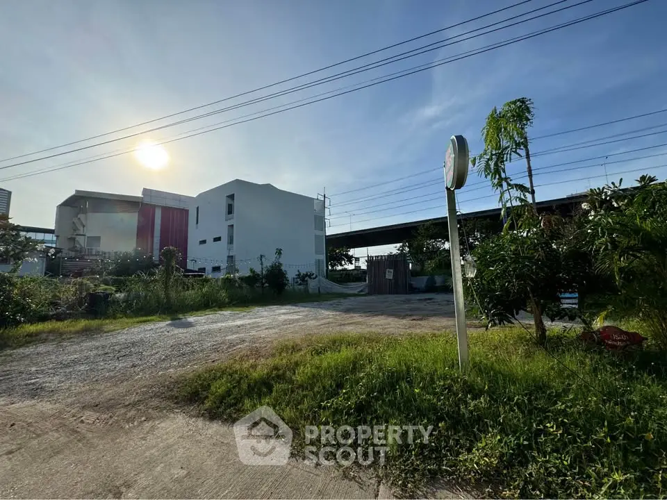 Modern building exterior with lush greenery and clear sky, ideal for urban living.