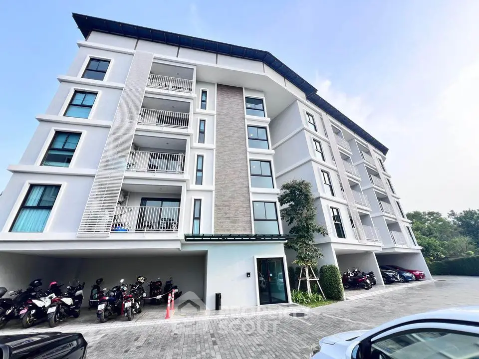 Modern apartment building with spacious balconies and parking area