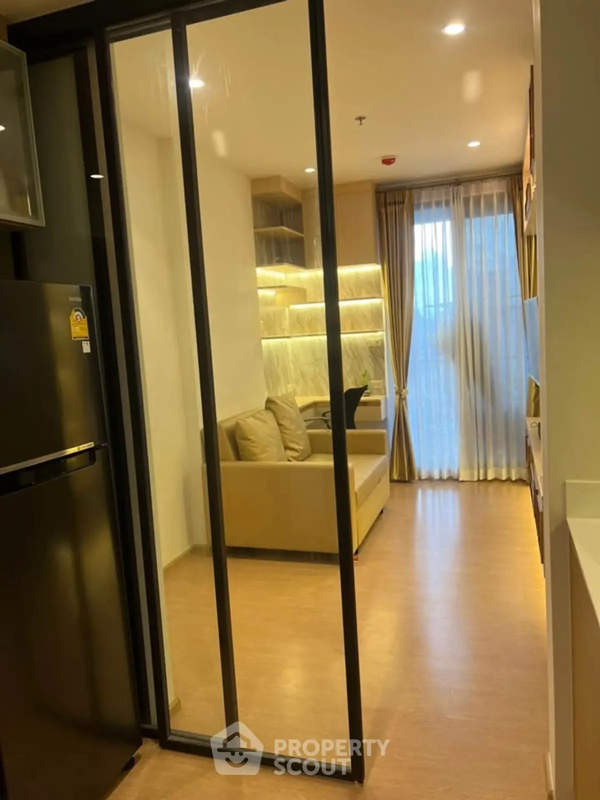 Modern living room with sliding glass door and cozy sofa in a stylish apartment.