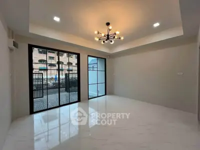 Spacious modern living room with elegant lighting and large windows offering ample natural light.