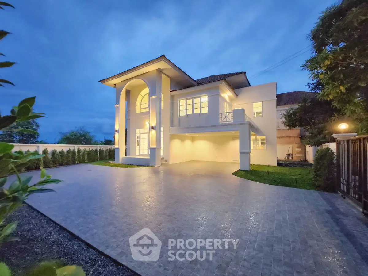 Stunning two-story modern home with spacious driveway and elegant lighting at dusk.
