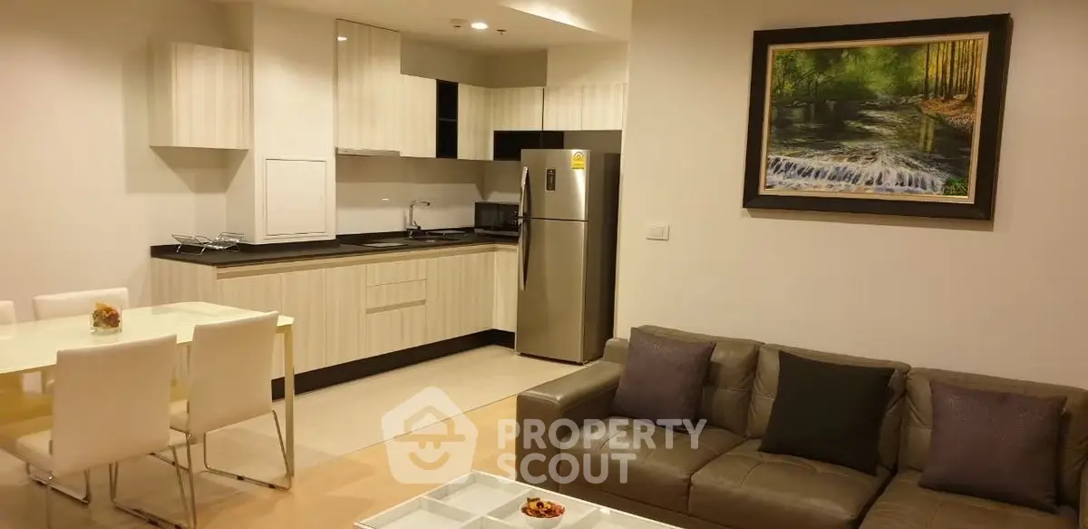 Modern open-layout kitchen and living room with stylish decor and stainless steel appliances.