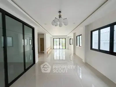 Spacious modern living room with sleek glass doors and abundant natural light.