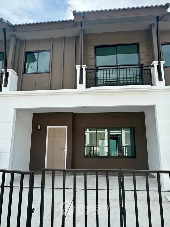 Modern townhouse exterior with sleek design and gated entrance, perfect for urban living.