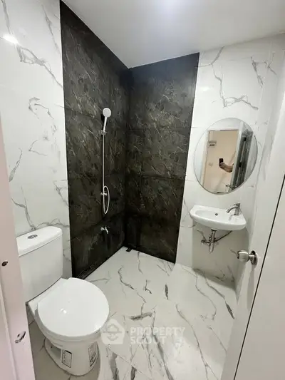 Modern bathroom with marble tiles and sleek fixtures in a contemporary apartment.
