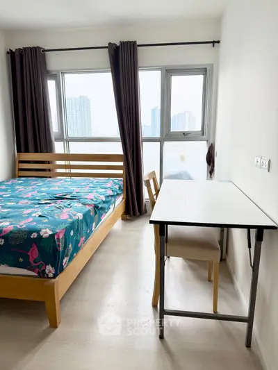 Bright bedroom with city view, wooden bed, and study desk in modern apartment.