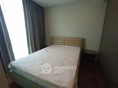 Cozy bedroom with natural light and modern furnishings in a stylish apartment.