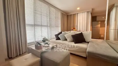 Modern living room with cozy seating and large windows in a stylish apartment.