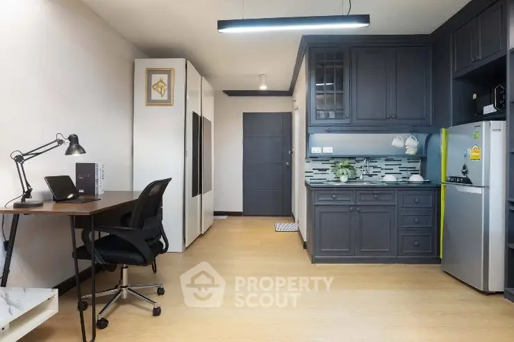 Modern studio apartment with sleek kitchen and workspace, ideal for urban living.