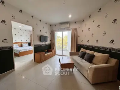 Spacious living room with elegant decor and natural light, featuring a cozy sofa and modern TV setup.
