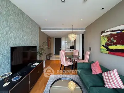 Stylish living room with modern decor and open layout, featuring a chic dining area and vibrant artwork.