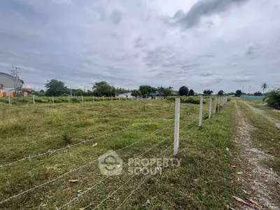 Expansive plot of land with lush greenery and clear skies, ideal for development.