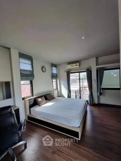 Spacious bedroom with modern decor and large windows offering ample natural light.