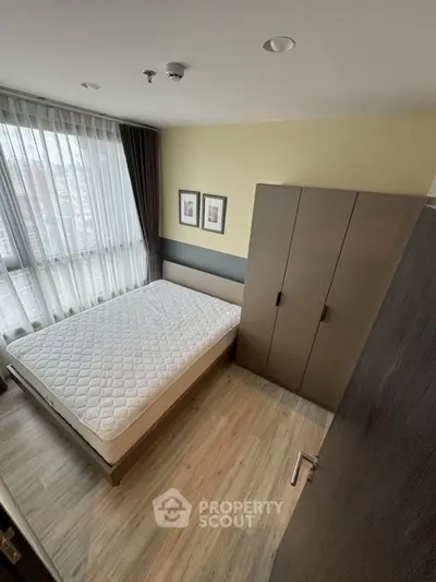 Modern bedroom with large window and stylish wardrobe in urban apartment